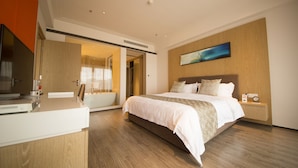 A modern hotel room with a large bed, a desk, a bathtub, and a painting on the wall. - Dahengqin Superior Talent Hotel (Hengqin Port Branch) (Zhuhai)