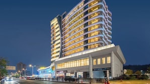 A modern hotel with multiple floors, a prominent entrance, and a well-lit facade. - Dahengqin Superior Talent Hotel (Hengqin Port Branch) (Zhuhai)