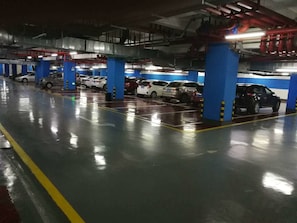 An underground parking garage with multiple levels, blue pillars, and cars parked in designated spaces. - Dahengqin Superior Talent Hotel (Hengqin Port Branch) (Zhuhai)