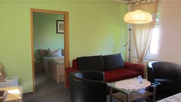 Familienzimmer, 2 Schlafzimmer, Gartenblick | Wohnbereich | Flachbildfernseher