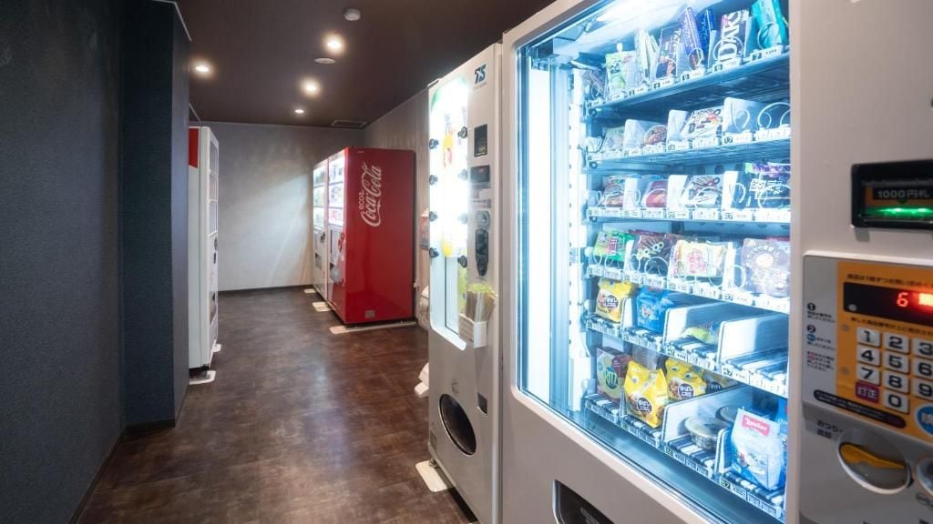 A vending machine area with various snack options and a Coca-Cola refrigerator.