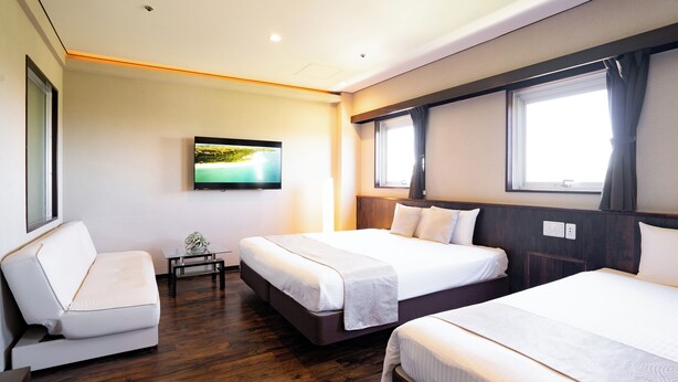 A hotel room with two beds, a TV on the wall, and a window with curtains. - Rycom Crystal Hotel (Okinawa)