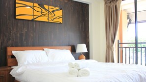 A neatly made bed with white linens, a wooden headboard, and a bedside table with a lamp. - B&Y Residence (Chiang Mai)