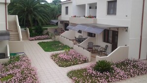 A courtyard with a covered seating area, a staircase, and a pool. - Amari Hotel (Polygyros)