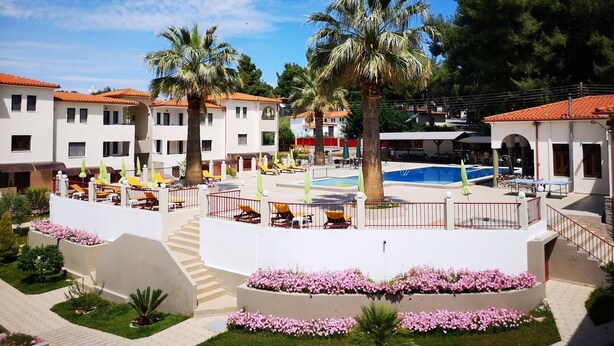 A resort with multiple buildings, a swimming pool, and outdoor seating areas. - Amari Hotel (Polygyros)