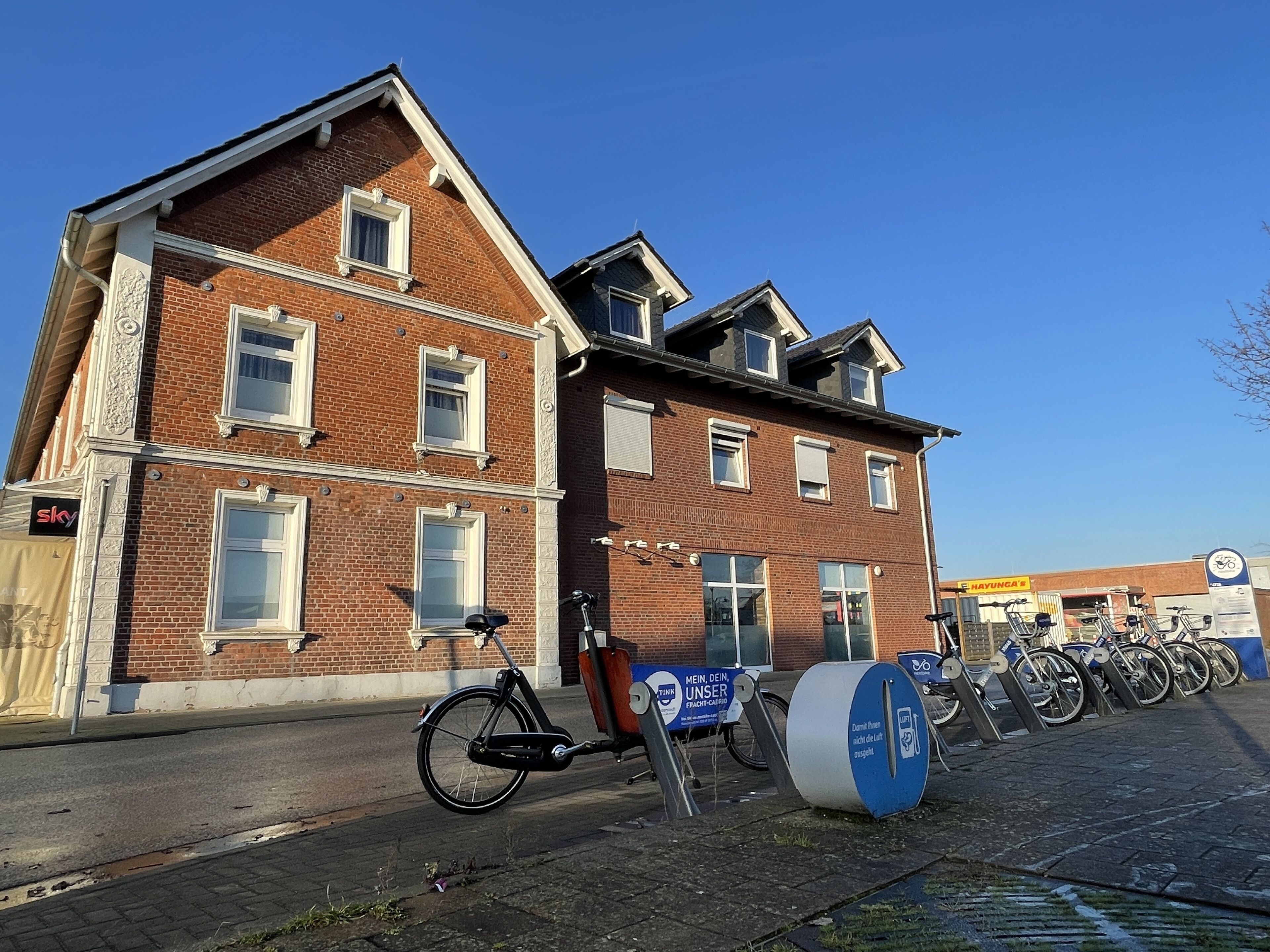 Un edificio de ladrillo con una bicicleta estacionada adelante.