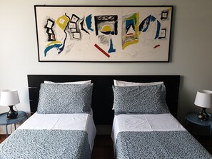 A hotel room with two beds, white bedding, a black headboard, and a large abstract painting on the wall. - B&B Villa al Parco (Sala Baganza)