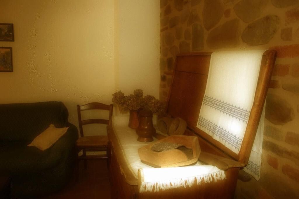 A cozy living room with a stone wall, a wooden cabinet, a woven basket, and a green sofa.