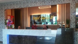 A hotel reception area with a marble counter, a reception desk, and a sign that reads "Hotel Surin-18". - Hotel Suria 18 (Ipoh)