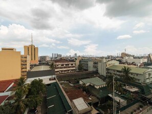A cityscape with various buildings, including a tall structure with antennas. - RedDoorz Plus @ Banawe Quezon City Weekly Stay (Quezon City)
