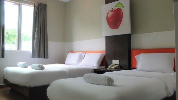 A hotel room with two beds, a window with curtains, a painting of an apple on the wall, and a telephone on the nightstand. -  JQ Suria Hotel (Ipoh)