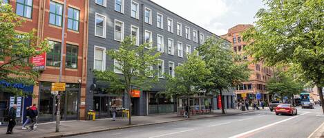 A multi-story building with a bus lane on the street.