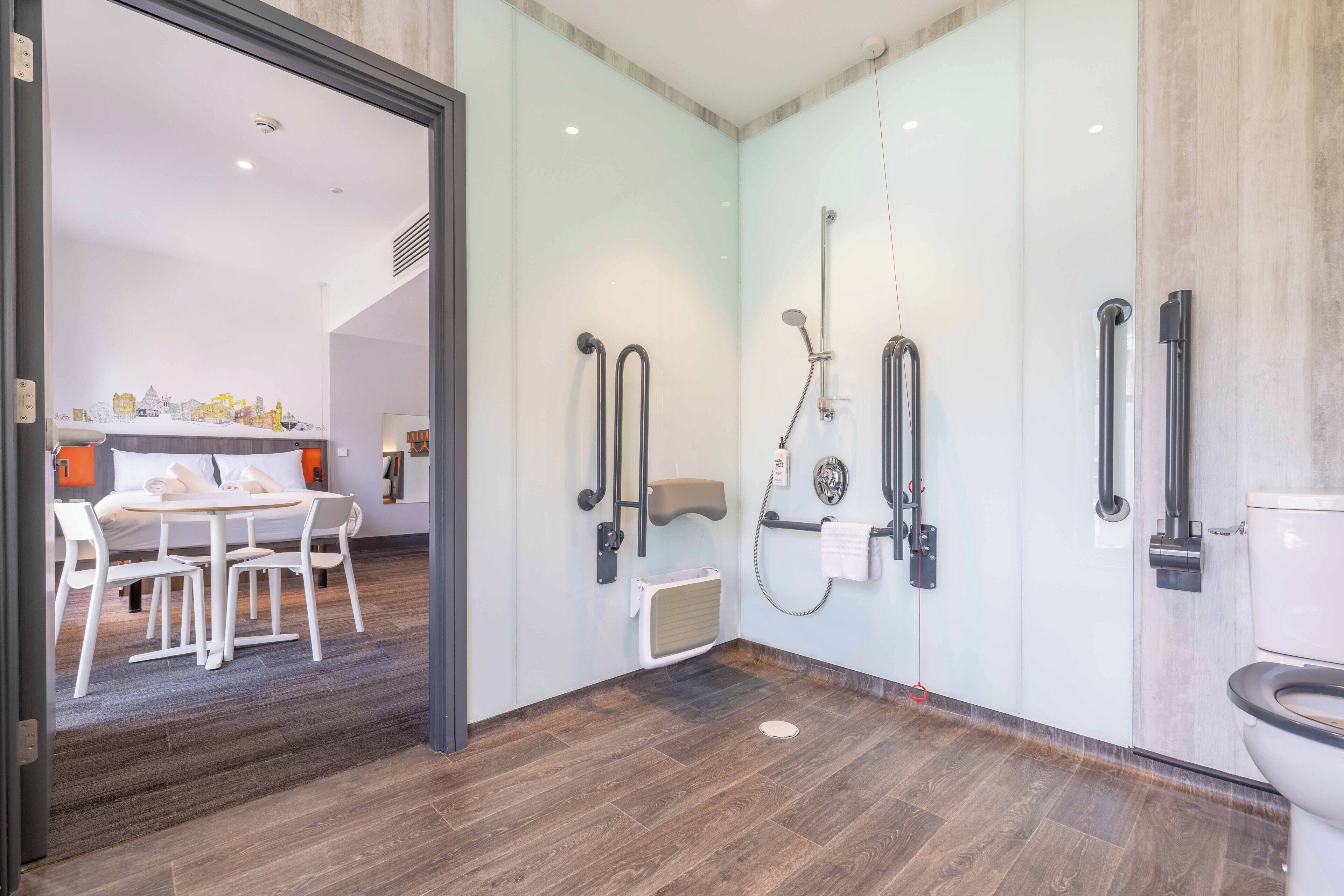A modern bathroom with a glass shower enclosure, a toilet, and a sink.