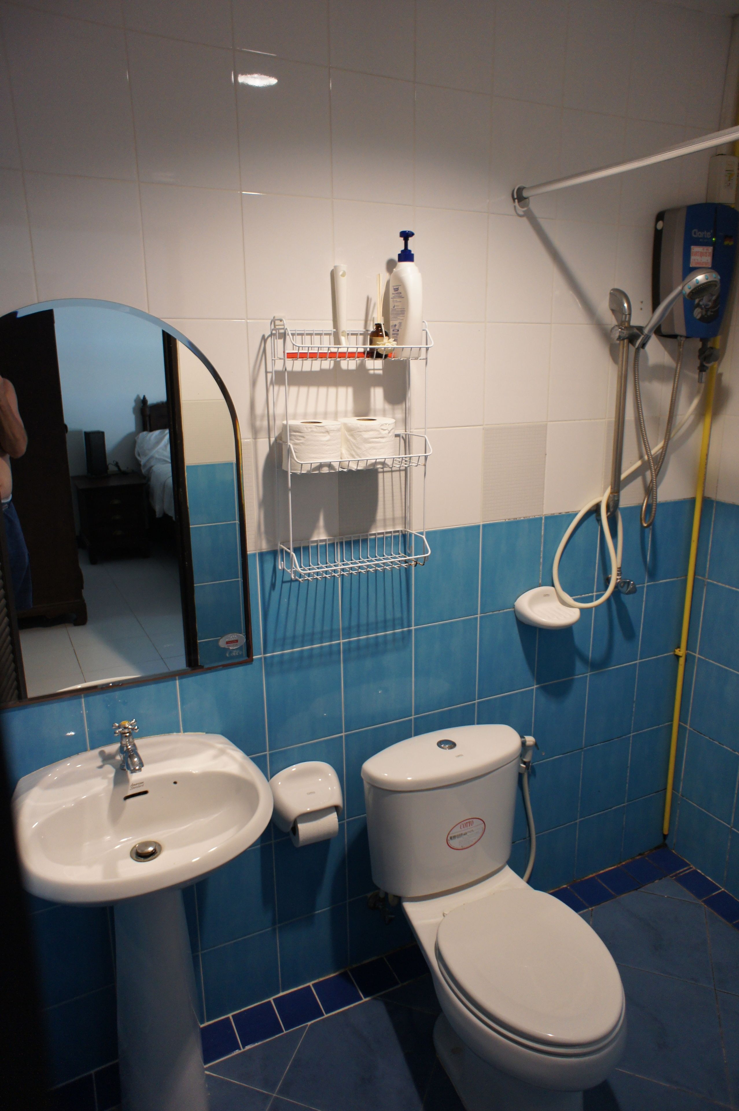 A bathroom with a sink, toilet, and a mirror.