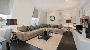 Un salon moderne avec un canapé, une table basse et un bureau avec une lampe.