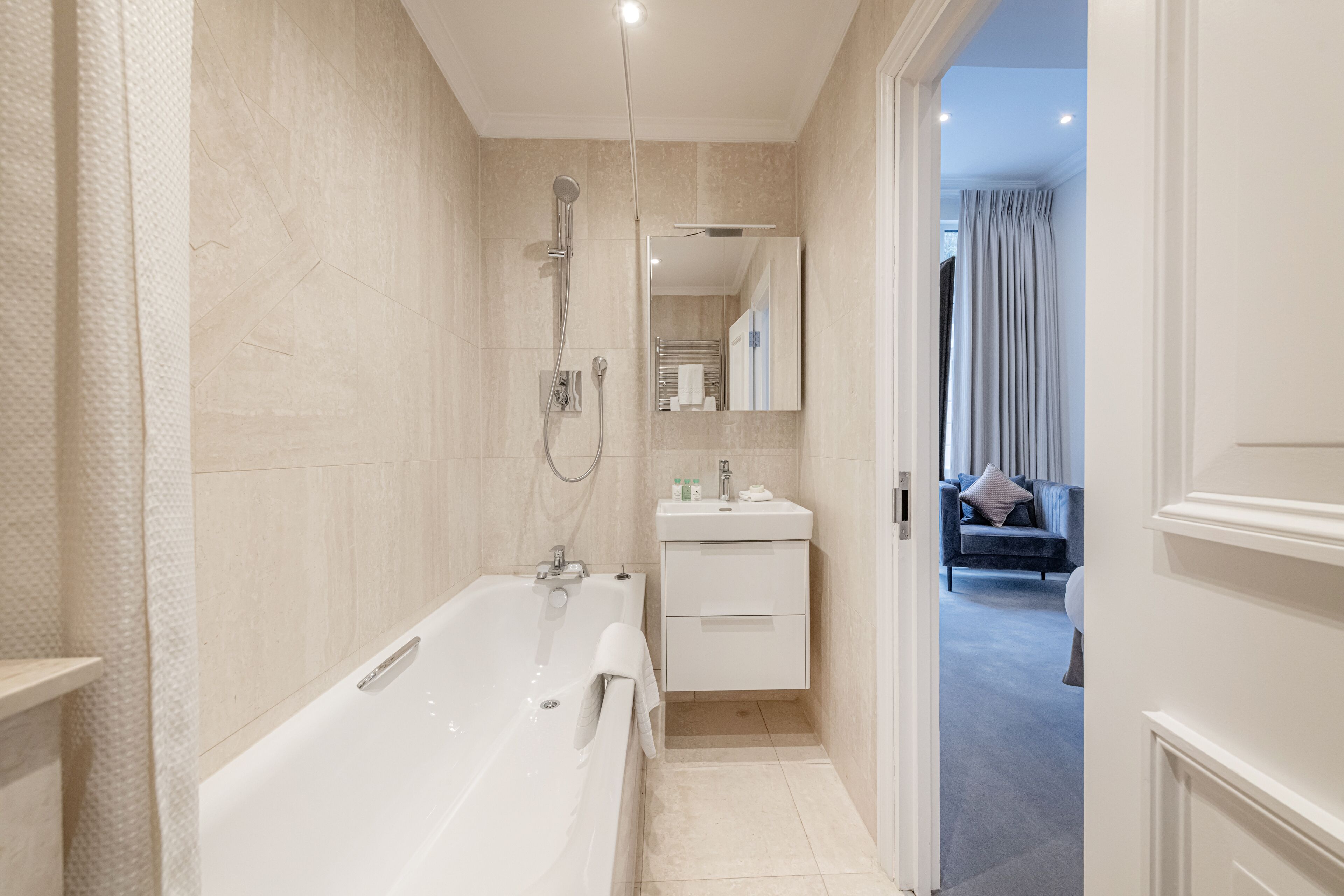 Ein modernes Badezimmer mit einer großzügigen Badewanne, einer Dusche und einem Waschtisch mit Spiegel.
