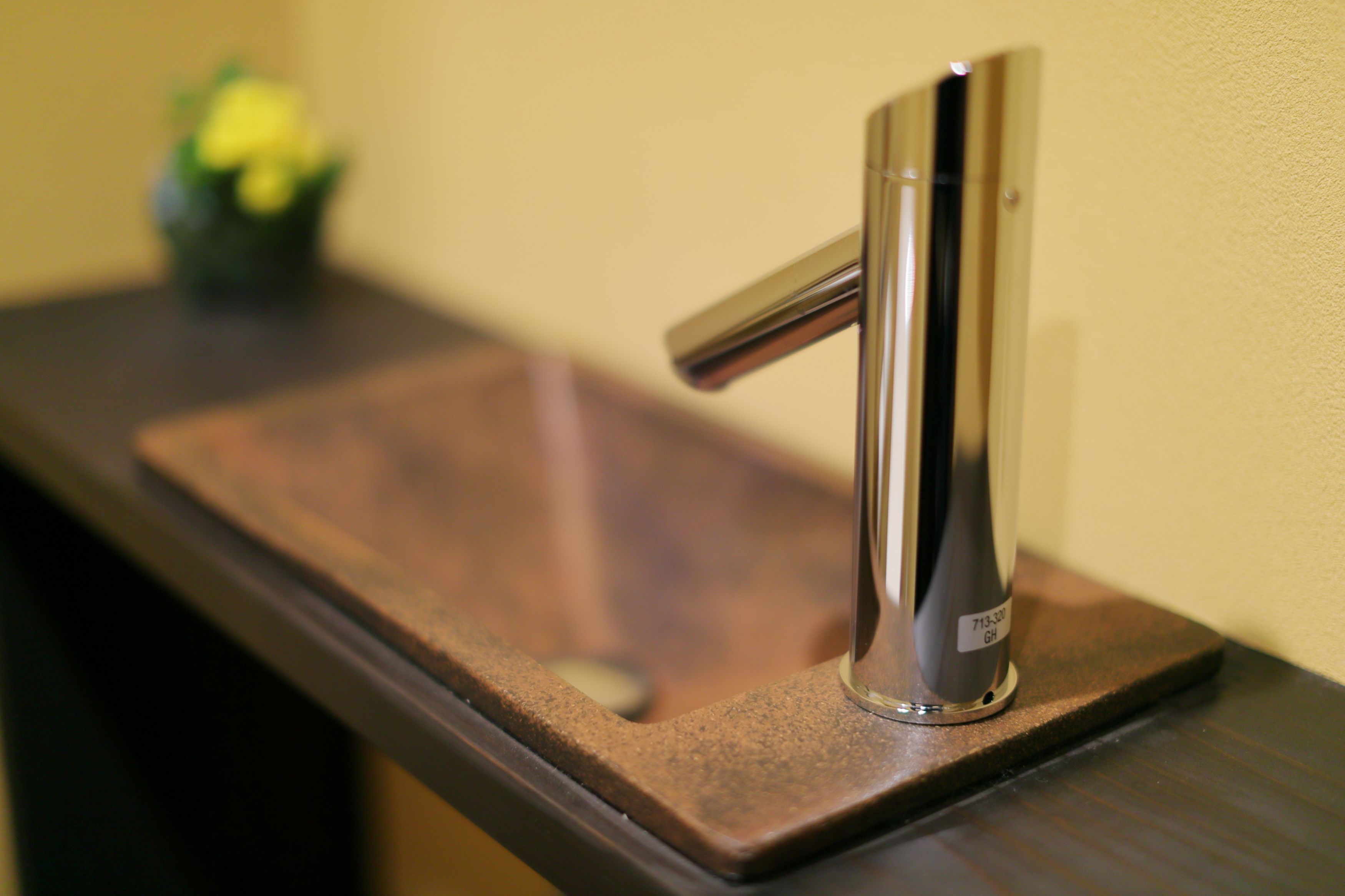 A modern bathroom sink with a chrome faucet and a rectangular basin.