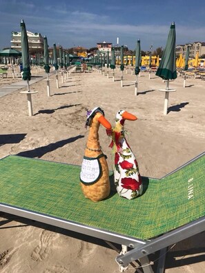 Een strand met rijen parasols en ligbedden.