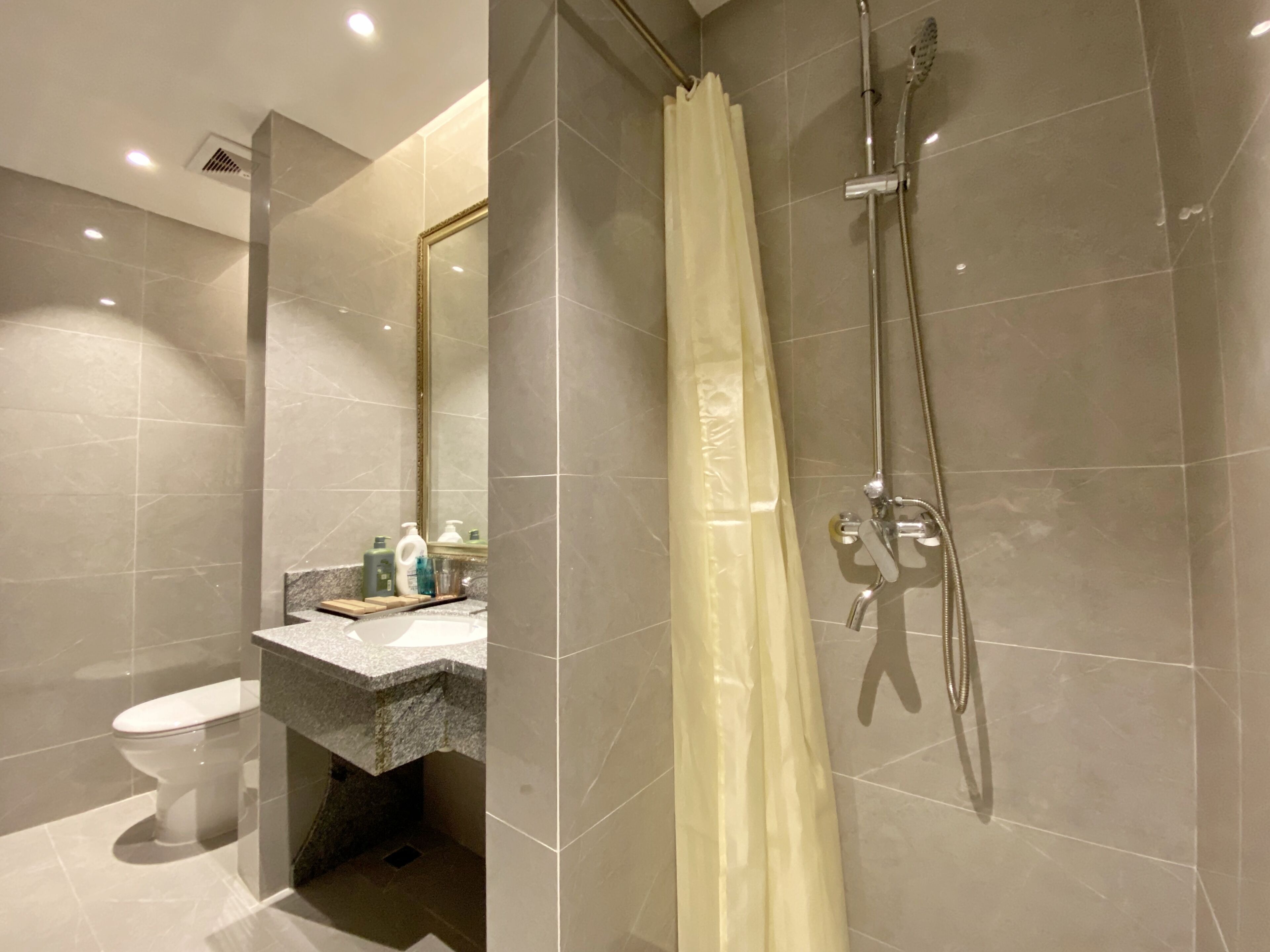 Une salle de bain moderne équipée d’une douche, de toilettes et d’un lavabo.