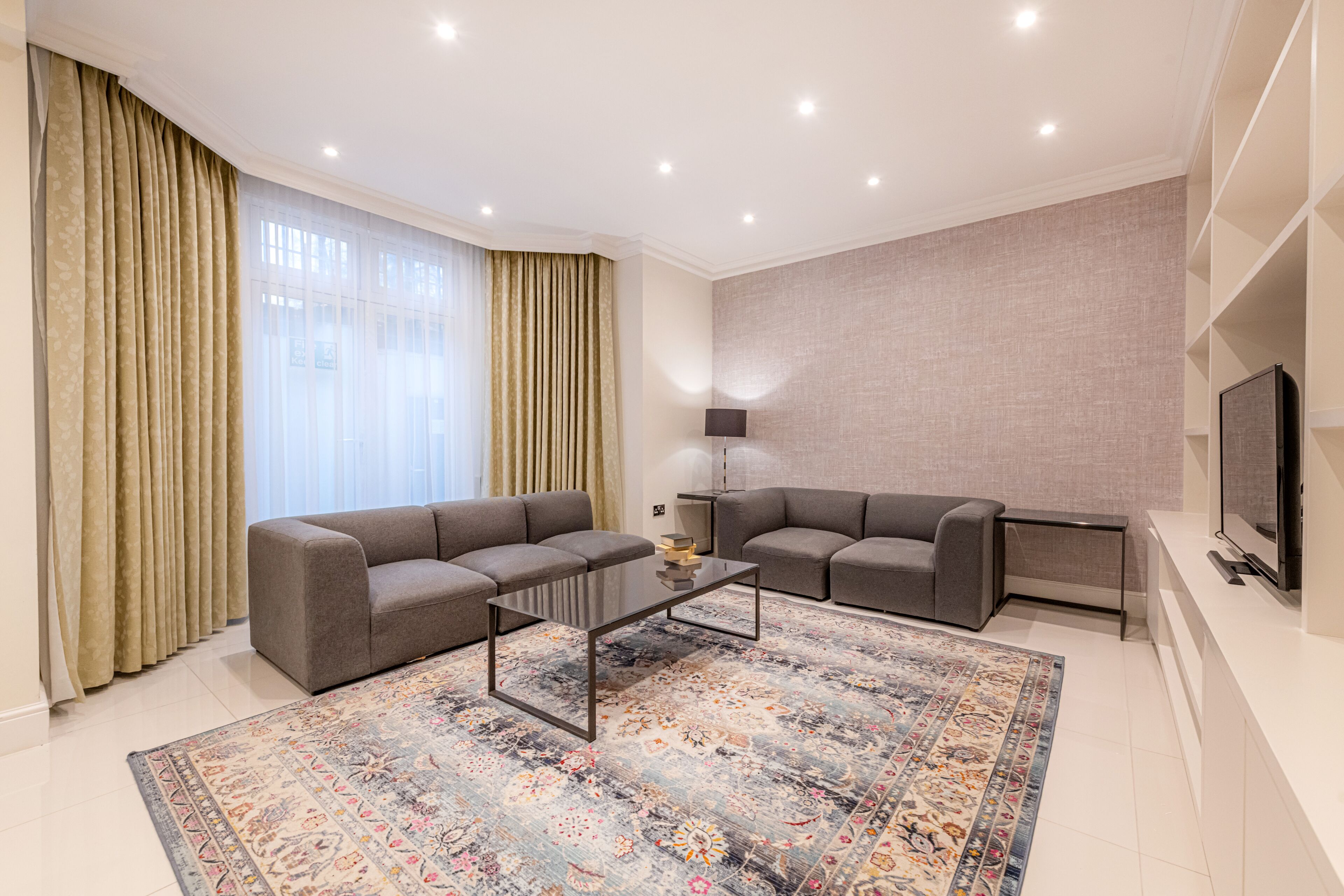 A modern living room with two sofas, a coffee table, and a television.