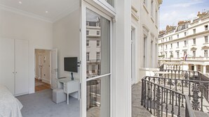 Une chambre moderne avec une grande fenêtre, un bureau et un téléviseur.