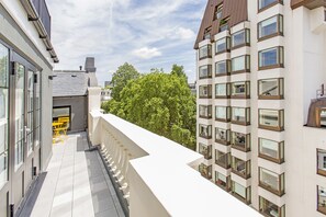 A modern building with multiple balconies, large windows, and a tree in the background. - Chesham Court (London)