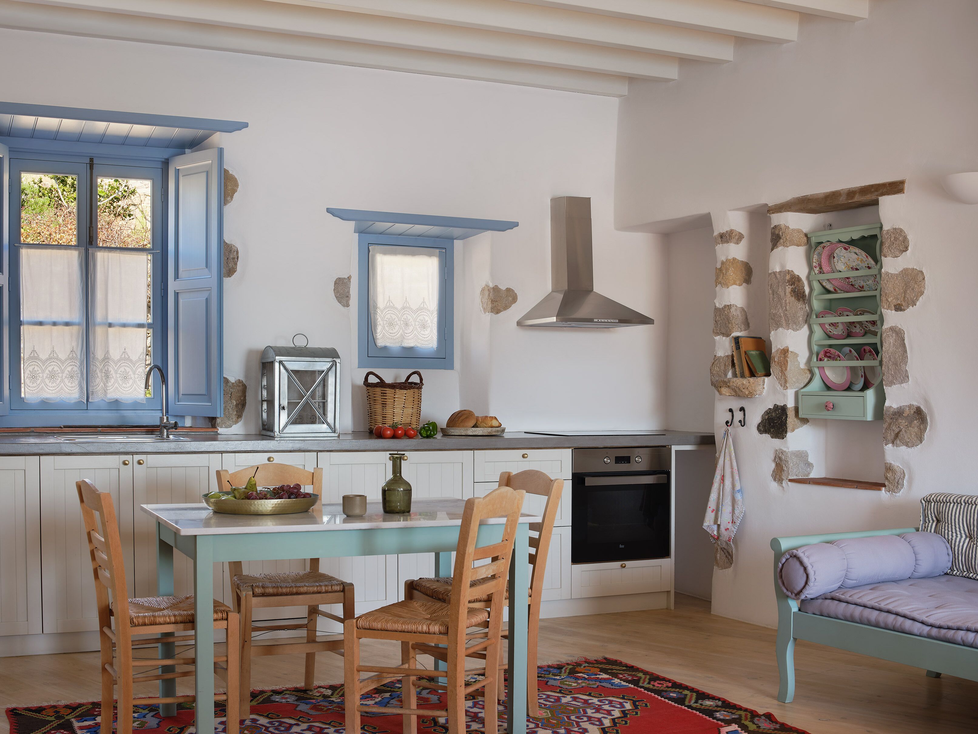 Une cuisine équipée d’une table à manger, de chaises, d’une cuisinière et d’un téléviseur.