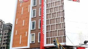 A modern hotel with a prominent 'Citi Hub' sign, large windows, and a red and white facade. - Grand Citihub Hotel at Panakkukang (Makassar)