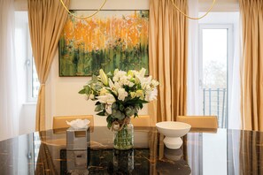 A dining table with a vase of white flowers, a tissue box, and a white bowl. - Fountain House (London)