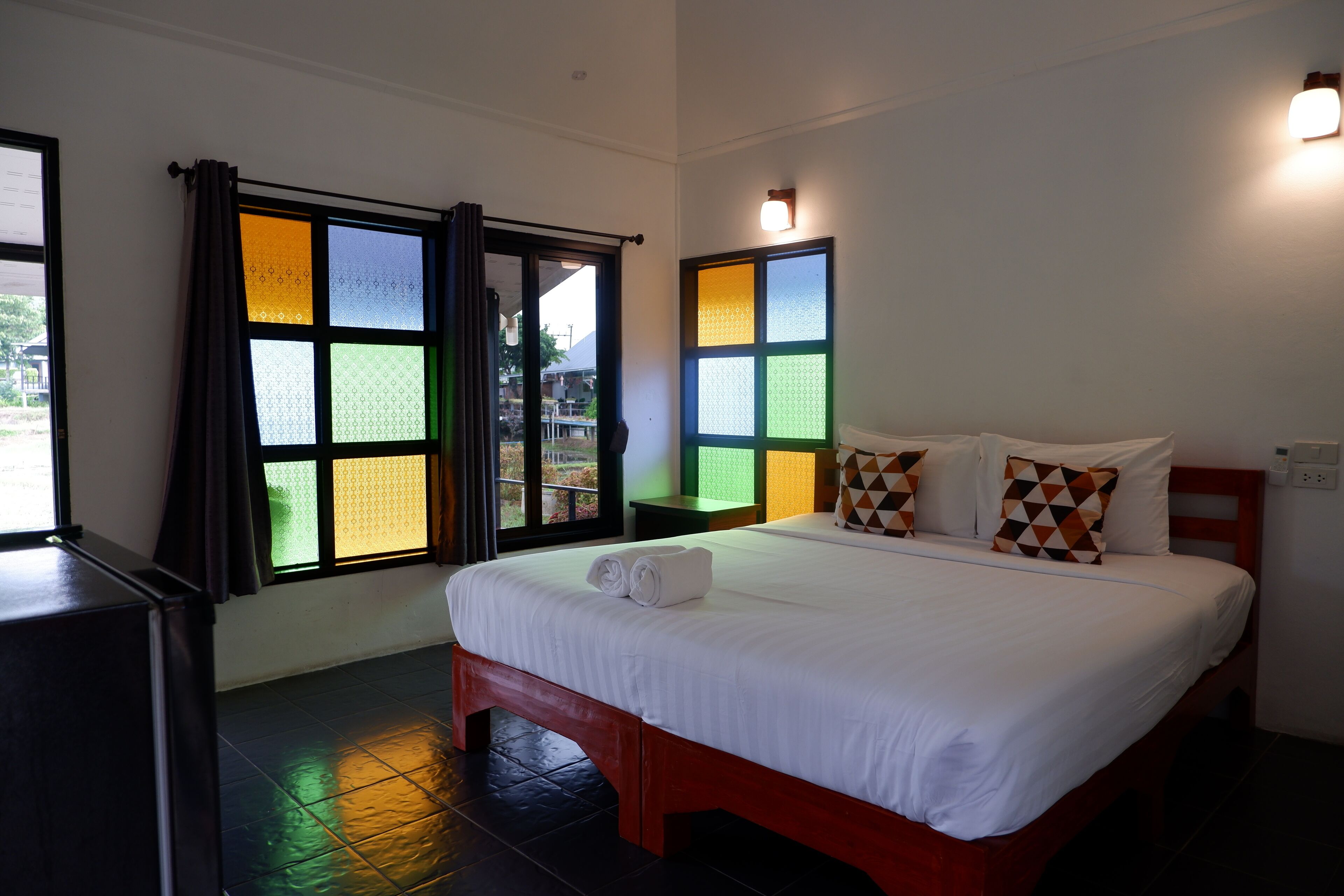 A hotel room with a bed, curtains, and a window with a view.