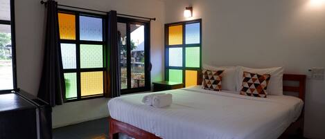 A hotel room with a bed, curtains, and a window with a view.