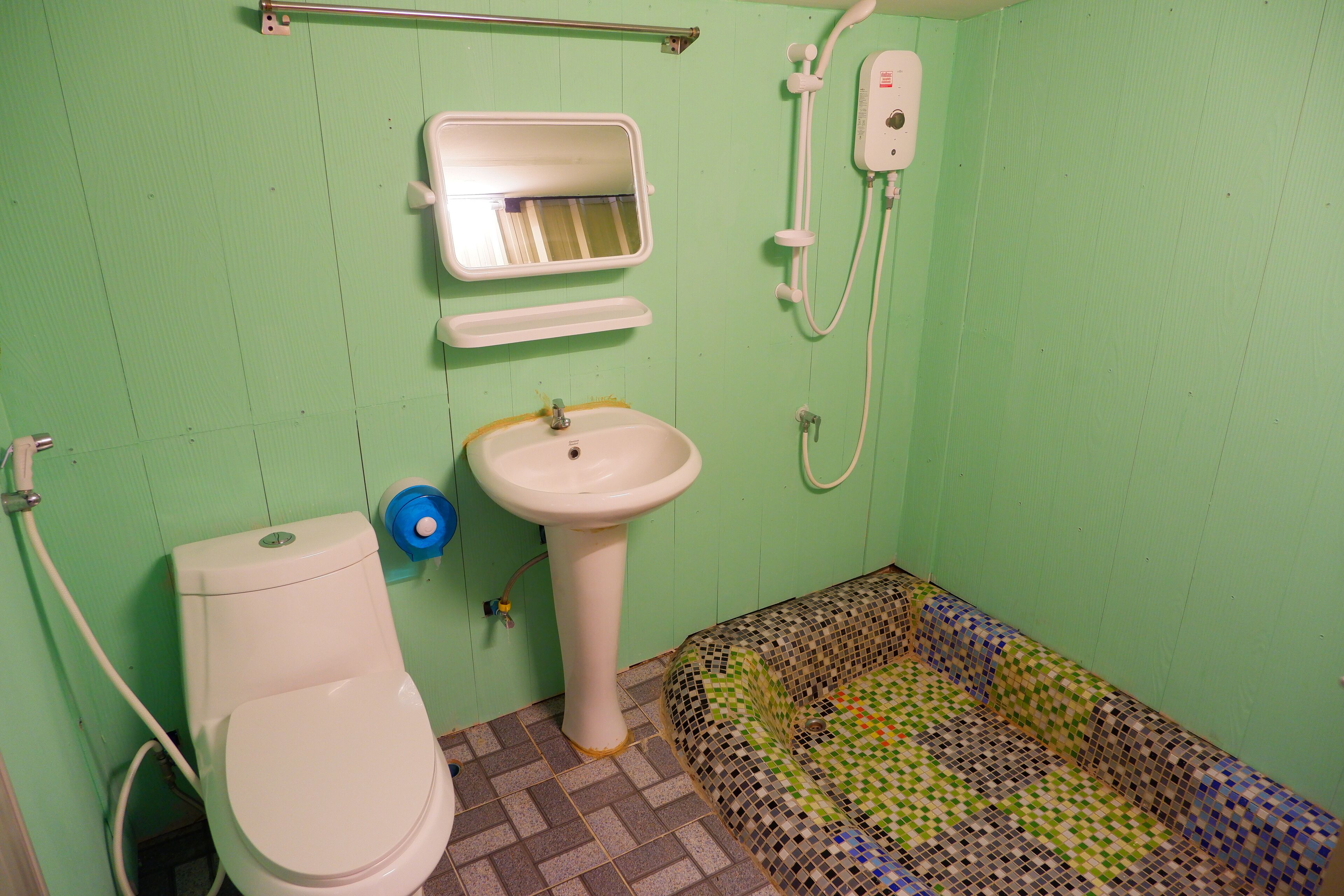 Een badkamer met toilet, wastafel en douche.