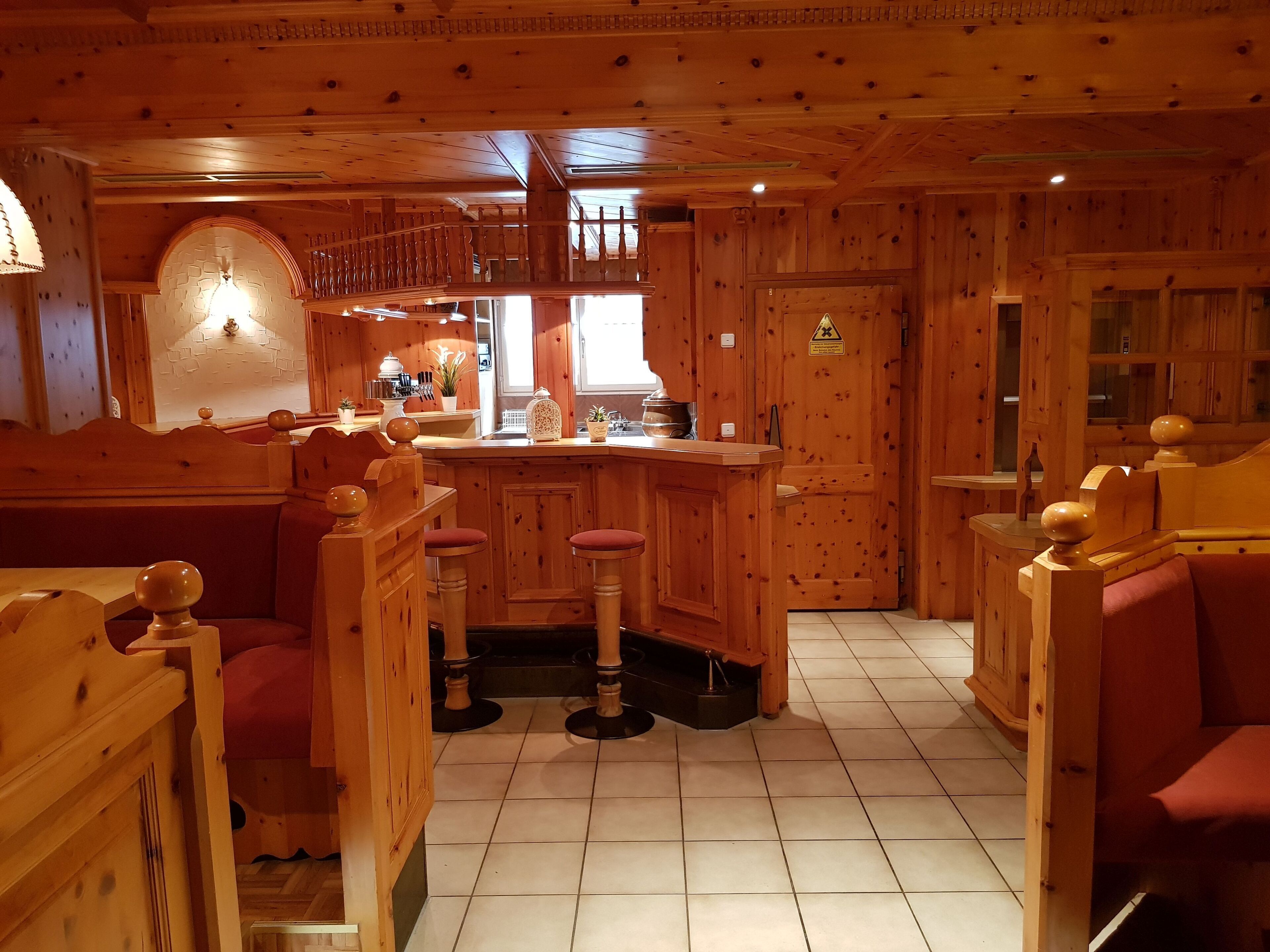 Interior de madera con barra, asientos y cocina.