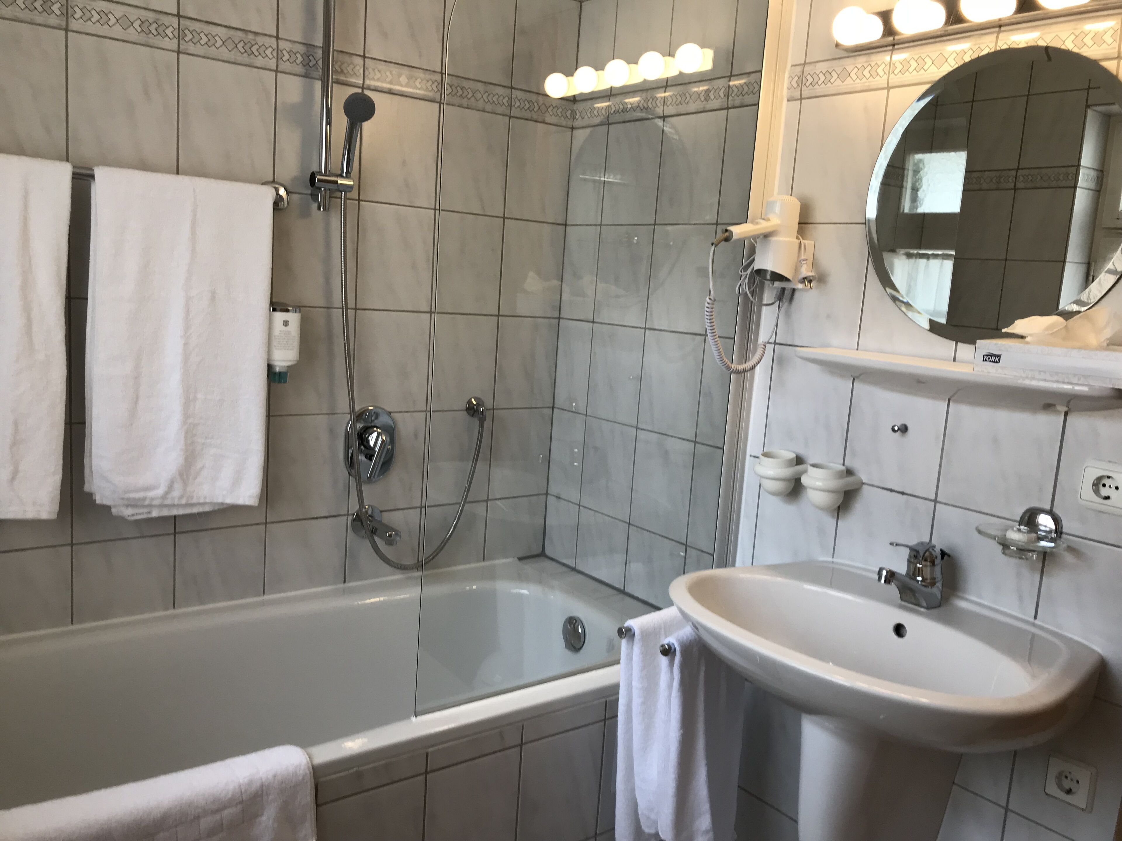 Een moderne badkamer met een bad, een wastafel en een douche.