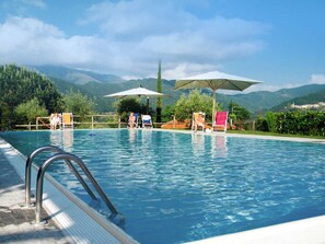 Een seizoensgebonden buitenzwembad en parasols bij het zwembad