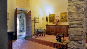 Una habitación con pared de piedra, muebles de madera, una máquina de coser antigua y un aparador de madera rústico.