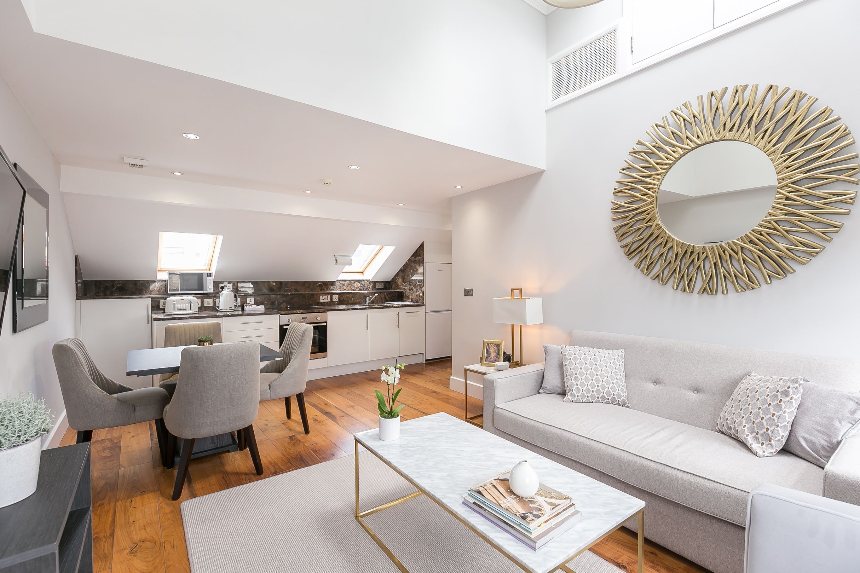 Un salon moderne avec un canapé, une table basse et un coin repas.