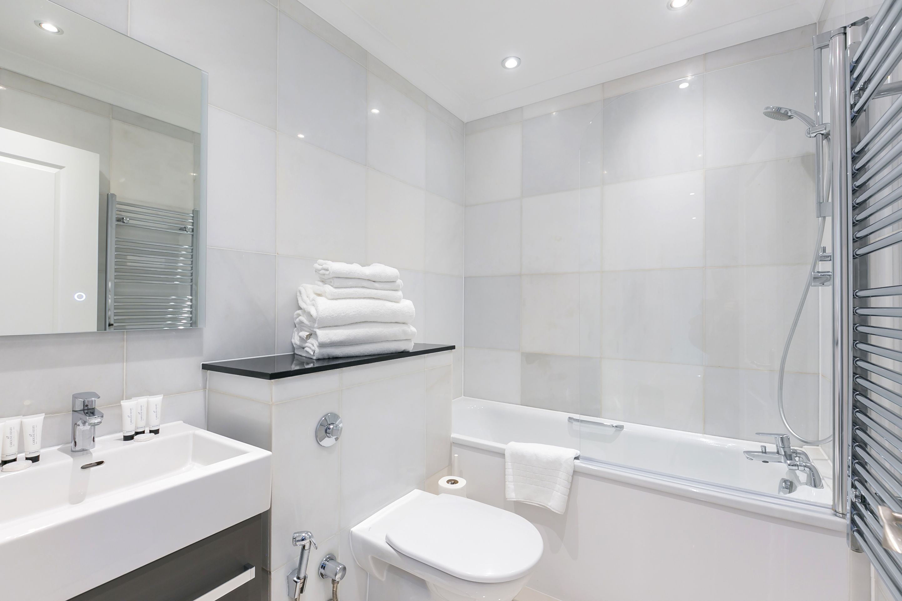 Een moderne badkamer met een wastafel, toilet en bad.