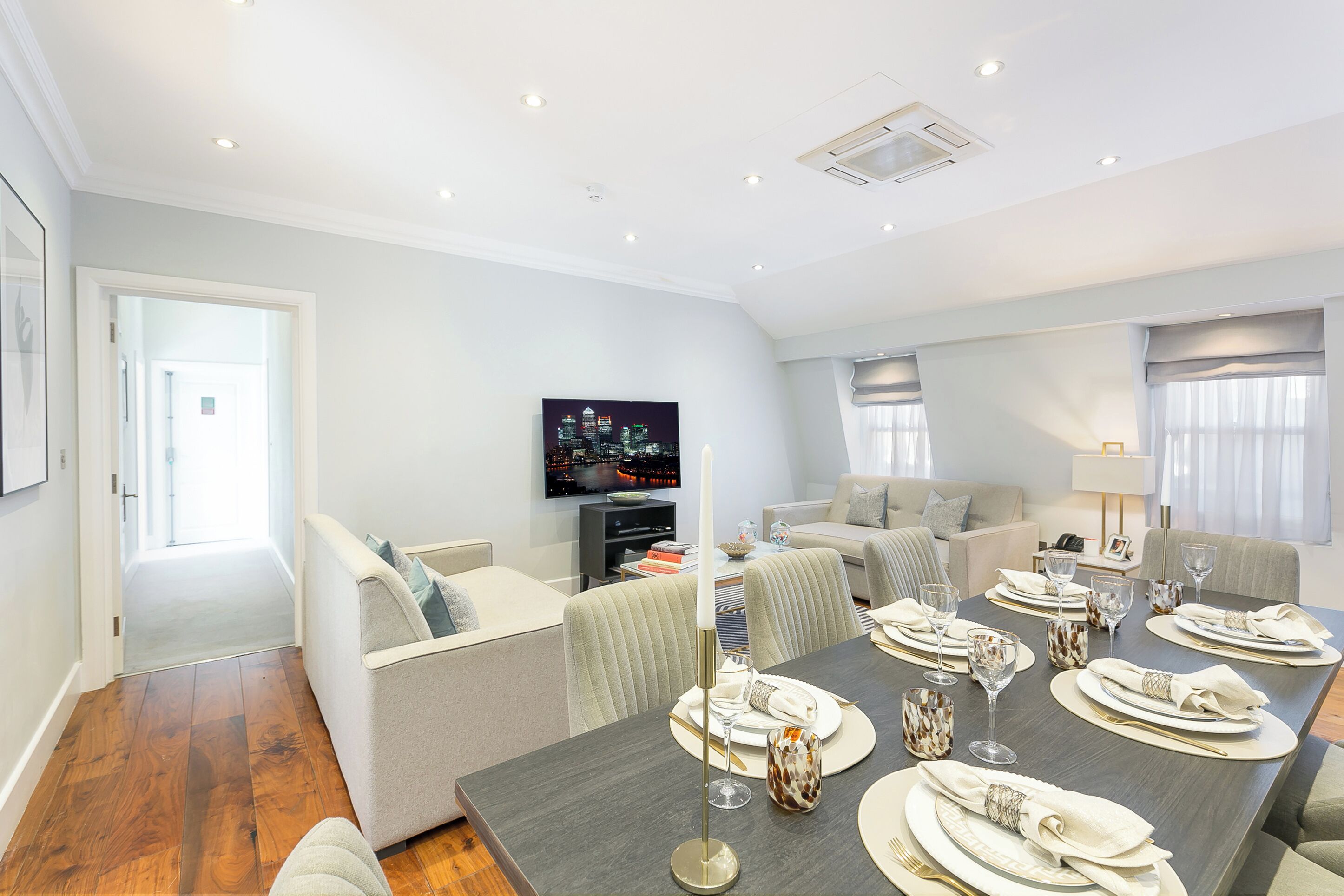 A modern living room with a dining area set for a meal.