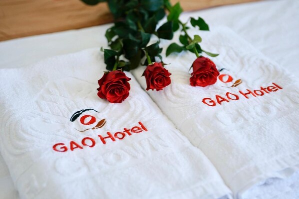 Dos toallas blancas con bordado de texto y rosas rojas.