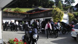 Un estacionamiento con motocicletas y un edificio al fondo.