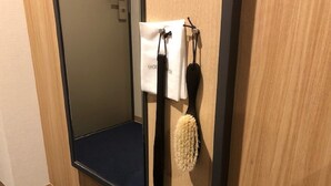 Un miroir, une serviette et une brosse à cheveux sont accrochés au mur.
