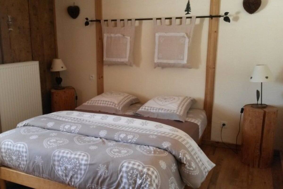 Ein Schlafzimmer mit einem Bett, zwei Nachttischen, einem Heizkörper und Wandleuchten.