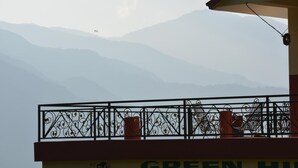 A balcony with a view of mountains, a Wi-Fi symbol, and the text "GREEN HILL".