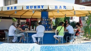 A bar named 'Bar Sunny Bar' with a poolside seating area and a Coca-Cola refrigerator. - Hotel Sunny (Sozopol)