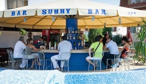 A bar named 'Bar Sunny Bar' with a poolside seating area and a Coca-Cola refrigerator. - Hotel Sunny (Sozopol)