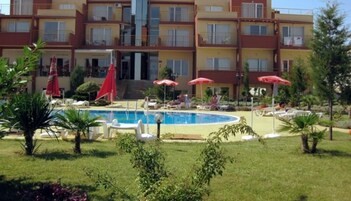 Un hotel con piscina, sillones de descanso y sombrillas.