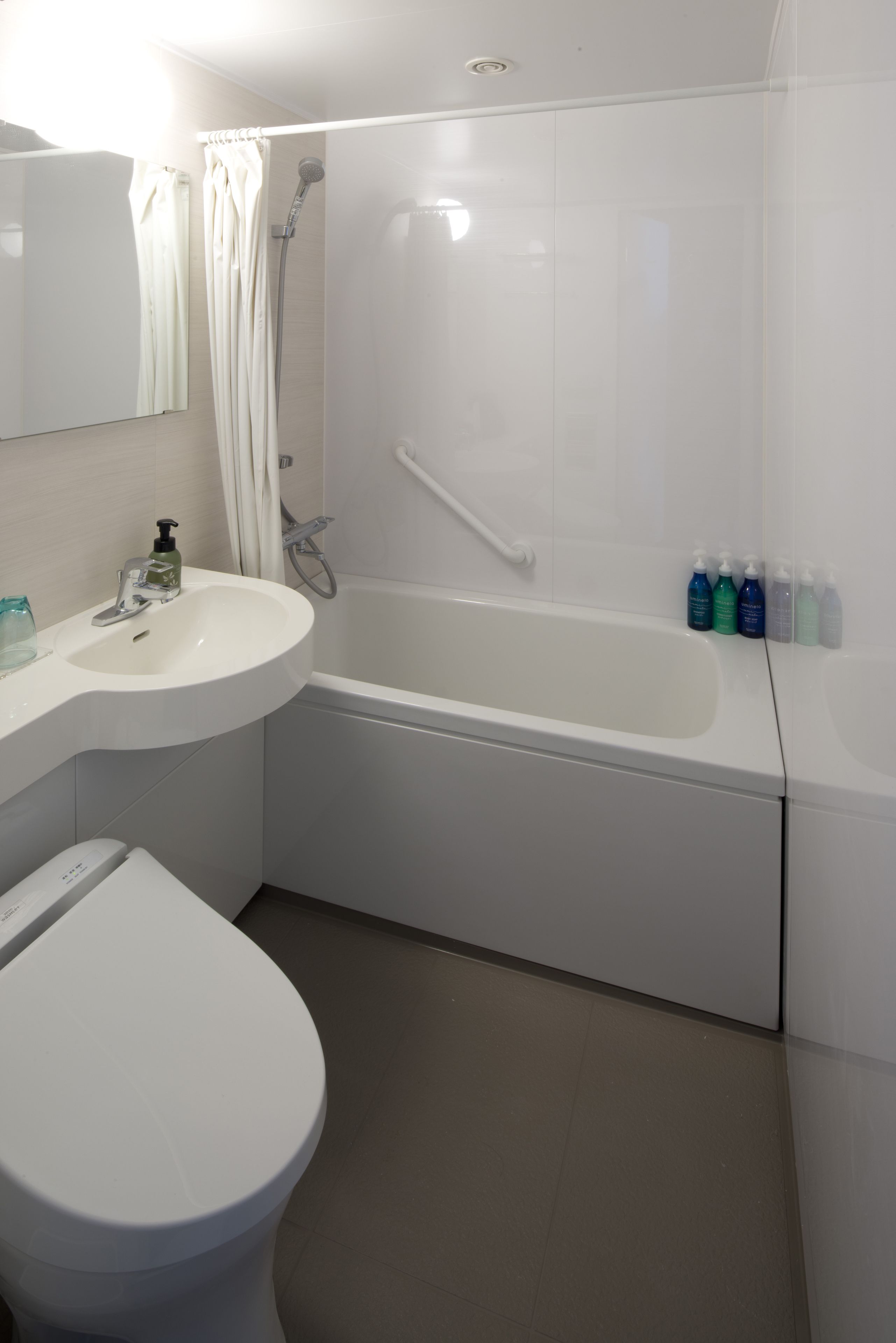 A modern bathroom with a white sink, toilet, and bathtub.