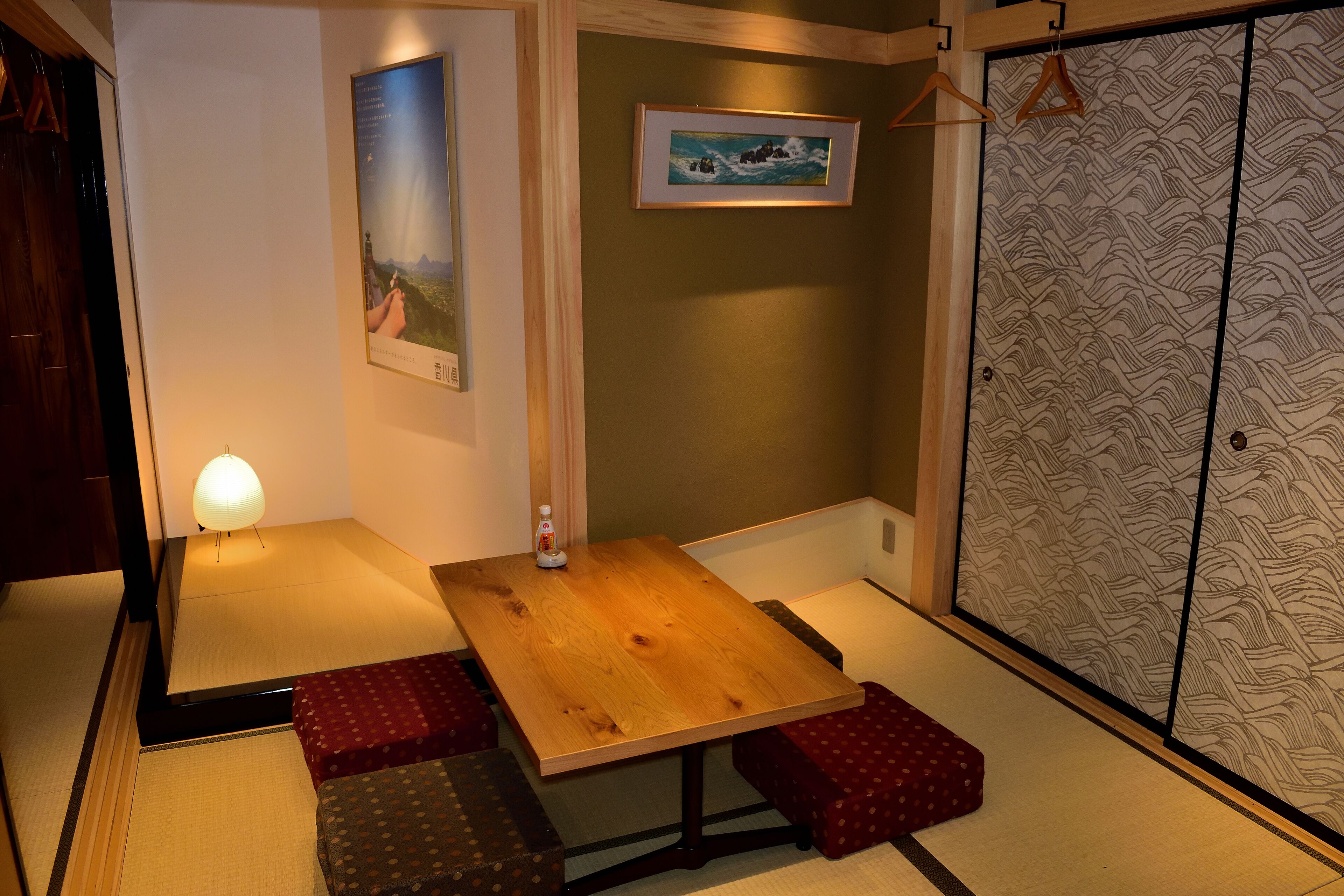 Una habitación japonesa tradicional con suelo de tatami, una mesa de madera baja y puertas correderas shoji.