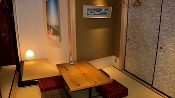 A traditional Japanese room with tatami flooring, a low wooden table, and shoji screens.